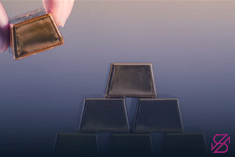 تصویر انگشتانی که شمش‌های طلا را روی هم می‌گذارند 